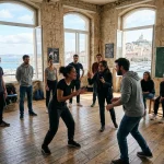 Formation acteur Marseille: une scène de travail en classe avec élèves et deux comédiens au centre, en studio lumineux avec vue sur le port.