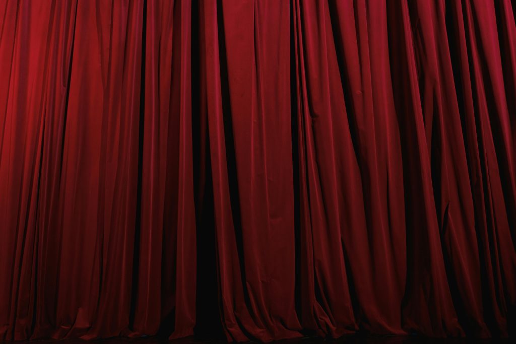 Stage curtains hung across a theater opening, suggesting a performance environment