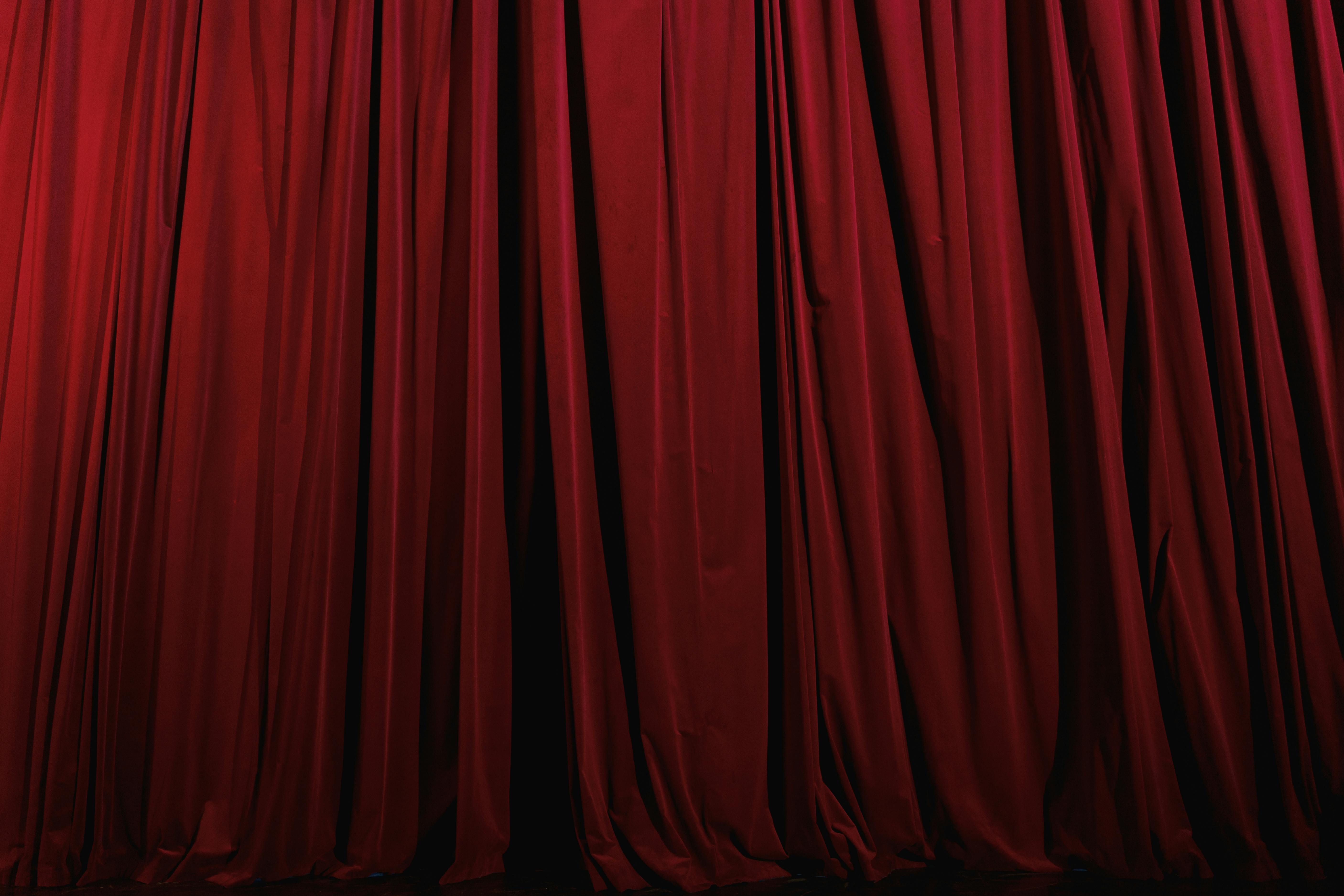Stage curtains hung across a theater opening, suggesting a performance environment